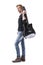 Side view of self assured confident young stylish rocker carrying guitar looking at camera.