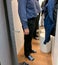 Side view of senior man in clothing store fitting room measuring new pair of