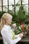 Side view of a senior woman using tablet pc in greenhouse