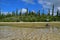 Side view of shallow brackish river stream with direction sign of Piscine Naturelle at Ile des Pins