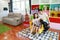 Side view shot happy asian family father, mother, and daughter sitting on sofa in colorful modern living room with relaxation and