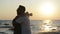 Side View of Silhouetted Couple Hugging on the Beach during Sunset near the Sea.