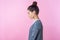 Side view of sleepy brunette teenage girl standing dreaming or imagining with closed eyes.  on pink background