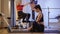 Side view of slim gorgeous sportswoman doing butterfly exercise in gym with blurred Caucasian woman using exercise