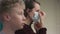 A side view slow motion portrait of a teacher and her student putting medical masks on their faces in turns before