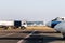 Side view small modern fuel tanker truck driving on airfield taxiway for aircraft refueling. Cistern lorry aviation