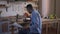 Side view of smart absorbed young African American man analyzing paperwork eating breakfast in kitchen. Engrossed