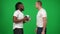 Side view smiling African American man shaking hands with Caucasian teammate passing football ball and looking at camera