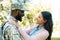 side view of smiling african american soldier in military uniform hugging girlfriend