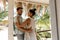 Side view of smiling caucasian young couple looking at each other while romancing in cottage balcony