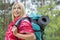 Side view smiling female backpacker in raincoat looking away at forest