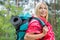 Side view smiling female backpacker in raincoat looking away at forest