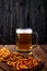 side view snacks for beer hard chuck chips and mini brezel with mug of beer on wooden background