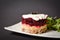 Side view of Soviet layered fish salad Herring under fur coat. Portion with marinated herring, onion, grated potato, beetroot,