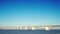 Side view of the static Zeeland Bridge under a clear blue sky. Flowing seawater