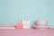 Side view on a still life. Pink fluffy pen, notepad and calendar on a pink table