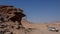 Side view of a stone man hanging from the rock above a shallow cave. The lone men are a mystery found in the northern Kaokoveld of