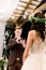 Side view of stylish groom reading his oath to the bride at a ceremony near the wedding arch, outdoors, standing in