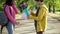 Side view teenage boy surprising unrecognizable girl with bouquet of flowers and gift bag with teddy bear. Loving