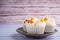 Side view of Thai steamed cupcakes topped with dry fruit on a plate with wooden wall background. Khanom Pui Fai in Thai