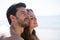 Side view of thoughtful couple sitting at beach