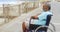 Side view of thoughtful disabled active senior African American man in wheelchair on promenade 4k