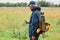 Side view of treasure hunter mature man in jacket and cap holding old coin in hands, looking with interest on his finding, senior