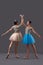 Side view of two ballerinas keeping hands up together