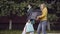 Side view of two confident Caucasian women with shopping boxes and bags walking outdoors chatting. Positive stylish