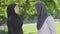 Side view of two emotional Muslim women quarrelling outdoors. Portrait of argued female friends having conflict on sunny