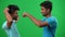 Side view two positive Middle Eastern men gesturing high-five on green screen smiling and hugging. Happy excited