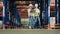 Side view of two warehouse workers moving between racking frames