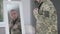 Side view of unrecognizable officer adjusting military uniform looking at blurred mirror reflection. Confident serious