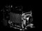 Side View of a Vintage Speed Graphic Bellows Press Camera on a Black Background