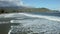 Side view of waves and surf rolling towards the beach at Hanalei on Hawaiian island of Kauai