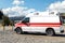 Side view of white ambulance rescue ems van car parked near countryside rural road at highland mountain resort area