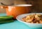 Side view of  a white bowl on an aqua blue table filled with homemade etouffee with shrimp and Andouille sausage.