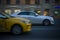 Side view of white Cadillac CTS driving on the road in evening. Night traffic scene