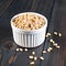 Side view of white cups, bowls with a handful of pine nut, cedar