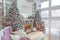 Side view of White living room with big windows and Christmas New year decor,light garland and Christmas tree