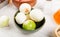 side view of white onions in bowl with potatoes in bowl salt butter around on wooden background