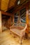 Side view of a wicker rattan bench on the outdoor terrace of a cottage.