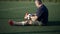 Side view wide shot mature sportsman amputee playing with soccer ball in slow motion talking sitting on summer stadium