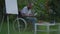 Side view wide shot portrait of desperate depressed disabled man in wheelchair admiring photo outdoors. African American