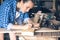 Side view of a woman carpenter draws on a wooden Board cut line