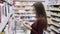 Side view of woman doing notes in shopping list at supermarket