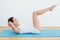 Side view of a woman doing stomach crunches on exercise mat