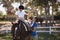 Side view of woman giving high five to girl sitting on horse