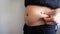 Side view of woman hand catching fat body belly paunch , diabetic risk factor
