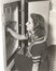 Side view of woman looking through refrigerator